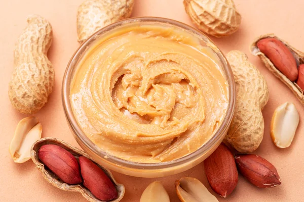 Tigela Manteiga Amendoim Amendoins Torno Dele Fundo Bege Vista Superior — Fotografia de Stock