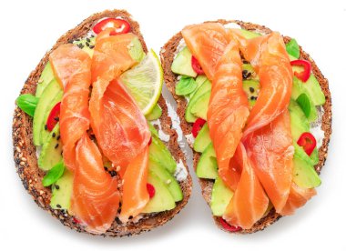 Beyaz arka planda izole edilmiş avokadolu somon tostları. Üst görünüm.