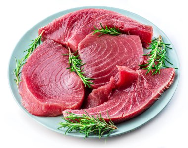 Fresh tuna steaks on blue plate isolated on white background.  