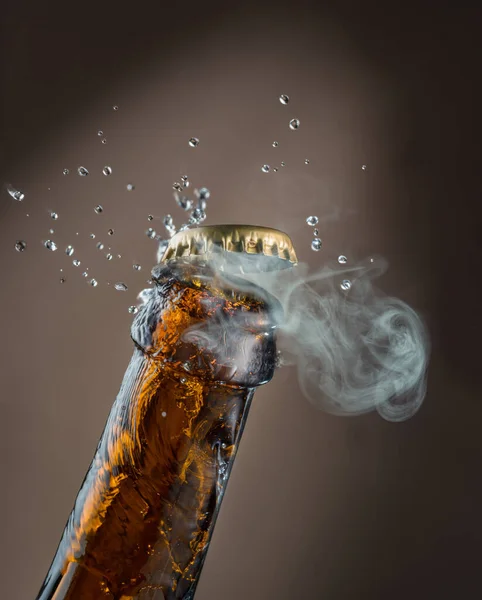 啤酒瓶口的开启过程 啤酒从瓶盖下的瓶颈上飞溅而出 — 图库照片
