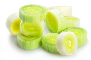 Beyaz arkaplanda taze doğranmış pırasa.