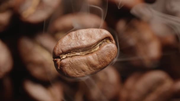 以烘烤咖啡豆为焦距背景的旋转咖啡豆宏观慢速运动视频 在烘烤过程中 咖啡豆被浓烟笼罩 — 图库视频影像