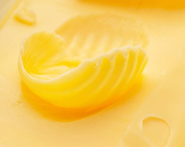 Tereyağı yakın çekim parçasının üzerine kıvrılır. Gıda arkaplanı.