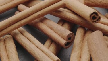 Kamera, tarçın çubuklarının yakınındaki gri bir taş masanın arka planında yavaşça hareket ediyor..