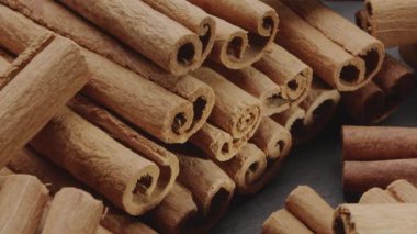 Kamera, tarçın çubuklarının yakınındaki gri bir taş masanın arka planında yavaşça hareket ediyor..