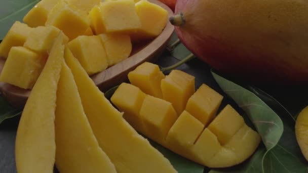 Rijp Mangovruchten Met Plakjes Mangobladeren Langzaam Het Frame Een Grijze — Stockvideo