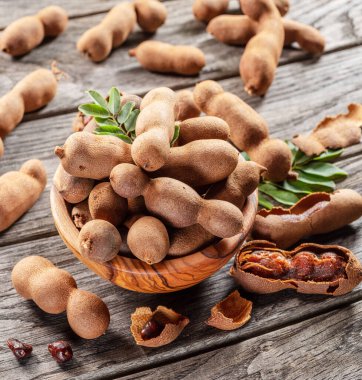 Olgun demirhindi meyvesi, yapraklar ve ahşap masada biraz demirhindi tohumu..