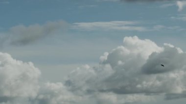 Bulutlu bir gökyüzünde, bulutların arasında uçan bir uçak. Projeleriniz için güzel tarafsız arkaplan.