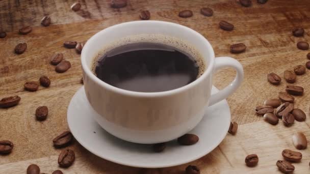 Biała Filiżanka Kawy Drewnianym Stole Ziarnami Kawy Rosnąca Para Powoli — Wideo stockowe