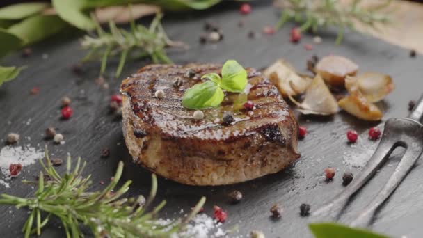 烤好的烤牛肉放在灰色的石头上 上面放着油炸大蒜和水蒸气 你的项目有很好的食物背景 — 图库视频影像