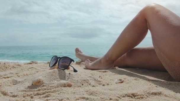 Mujer Sienta Una Playa Arena Día Soleado Verano Hermosas Piernas — Vídeos de Stock