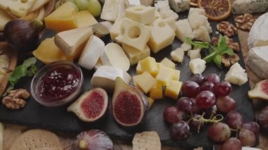 Meyveli, naneli, fındıklı ve peynirli dilimlenmiş peynirlerin çeşitliliği çerçevede yavaşça döner. Projeleriniz için harika bir peynir arka planı..