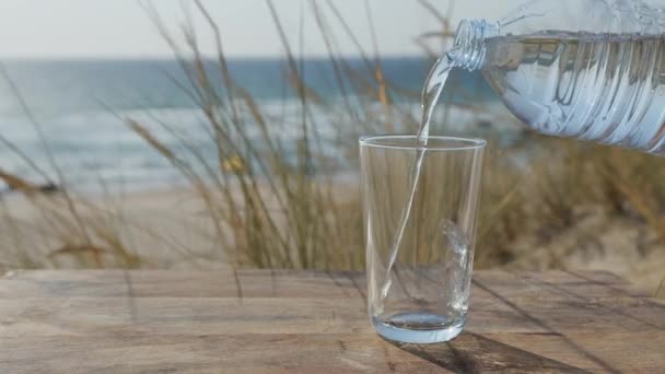 Água Derramada Copo Uma Garrafa Plástico Vista Para Mar Fundo — Vídeo de Stock