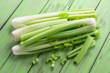 Yeşil ahşap masada bir yığın kereviz kaburgası. Sağlıklı gıda geçmişi.