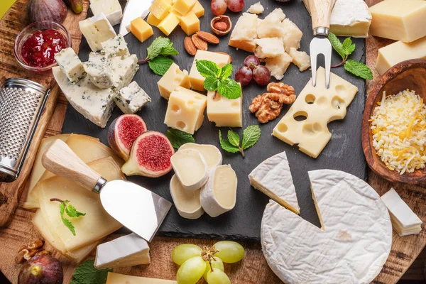 Verschiedene Käsesorten Mit Früchten Minze Nüssen Und Käseschneidemessern Wunderbarer Hintergrund — Stockfoto