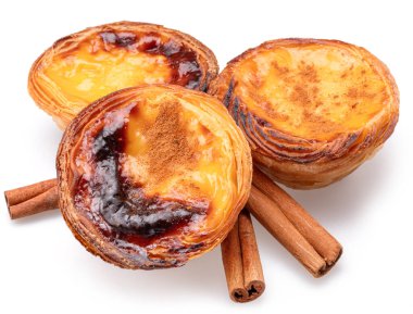 Pastel de nata turtaları ve tarçın çubukları beyaz arka planda izole edilmiş.. 