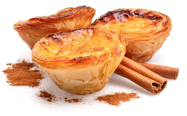 Pastel de nata turtaları ve tarçın çubukları beyaz arka planda izole edilmiş.. 