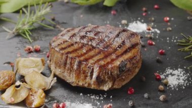 Kızarmış sarımsak ve buharla servis edilen gri bir taşta ızgara pirzola bifteği. Projeleriniz için harika yemek arkaplanı..