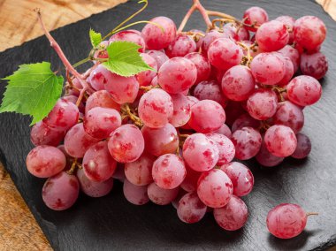 Cluster of red table grape with grape leaves isolated on white background. clipart