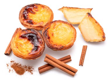 Pastel de nata turtaları ve tarçın çubukları beyaz arka planda izole edilmiş.. 