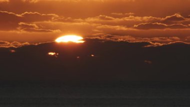 Büyük güneş ve bulutlarla güzel bir akşam günbatımı Portekiz 'deki Atlantik Okyanusu' nda.