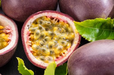 Olgun tutku meyveleri tutku meyveleri meyve tohumları ve tutku meyveleri gri bir taş masanın üzerinde. Projeleriniz için egzotik meyve arka planı.. 