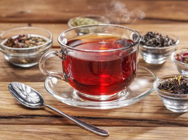 Ahşap arka planda bir fincan çay ve kuru çay. Üst görünüm.