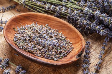 Masadaki ahşap kasede kurutulmuş lavanta çiçekleri. Üst görünüm.