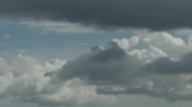 Bulutlu bir gökyüzünde, bulutların arasında uçan bir uçak. Projeleriniz için güzel tarafsız arkaplan.