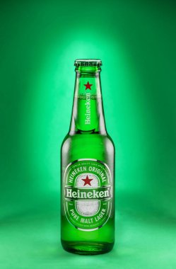 Portekiz, Lizbon, 9 Aralık 2023: Bir şişe Heineken birası 0.33l izole edilmiş yeşil arka plan. Heineken, dünyanın en popüler bira markalarından biridir..