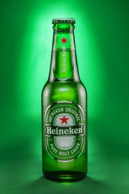 Portekiz, Lizbon, 9 Aralık 2023: Bir şişe Heineken birası 0.33l izole edilmiş yeşil arka plan. Heineken, dünyanın en popüler bira markalarından biridir..