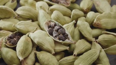 Bir sürü kakule baharatı saat yönünde yavaşça kayar, makro video görüntüleri. Projeleriniz için harika bir geçmiş..