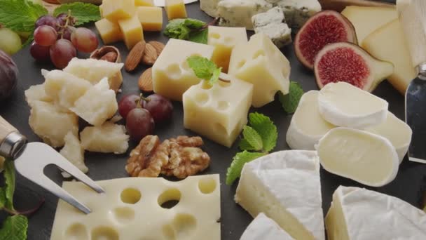 フレーム内でゆっくり回転するフルーツとスライスチーズのバリエーション あなたのプロジェクトのための素晴らしいチーズの背景 — ストック動画