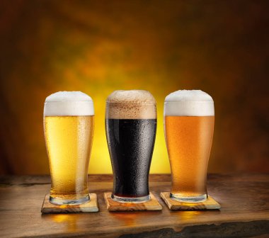 Farklı bardaklarda soğuk bira ve ahşap masa... 