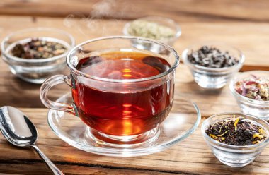 Ahşap arka planda bir fincan çay ve kuru çay. Üst görünüm.