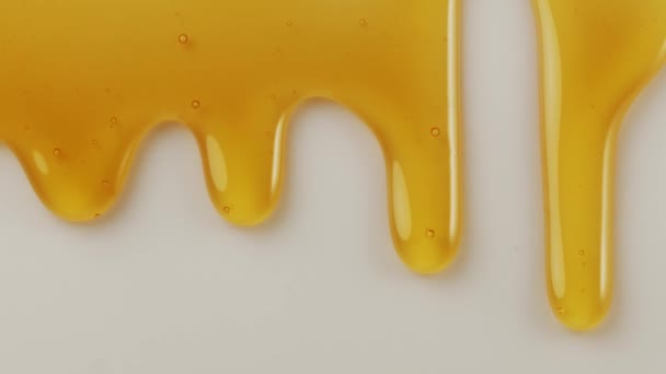 一滴滴蜂蜜慢慢地从白色的表面流下来 为你的项目提供一个极好的食物背景 — 图库视频影像
