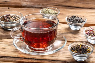 Ahşap arka planda bir fincan çay ve kuru çay. Üst görünüm.