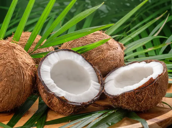 Friske Åbnede Kokosnødder Sammen Med Hele Kokosnødder Kokosnød Blade Træbord - Stock-foto