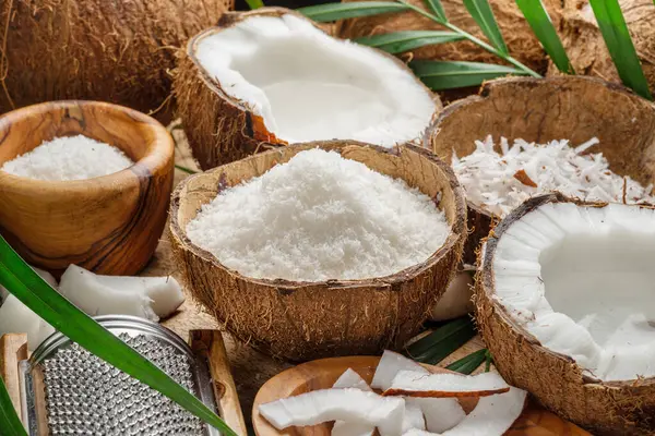 Färska Öppnade Kokosnötter Tillsammans Med Kokosskivor Flingor Och Kokosblad Ett Royaltyfria Stockbilder