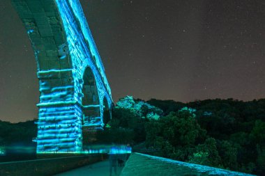 Pont du Gard, beş avroluk banknotta resmedilen antik bir Roma su kemeridir. Köprü gece aydınlandı. 2022 yazı..