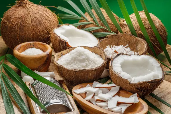 Friske Åbnede Kokosnødder Sammen Med Kokosnøddeskiver Flager Kokosnødeblade Træbord Flot - Stock-foto