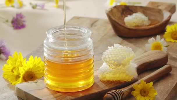 一滴滴蜂蜜慢慢地从一个木制的蜂蜜搅拌器流入一个蜂蜜碗 动作缓慢 为你的任何一个项目提供一个完美的食物背景 — 图库视频影像