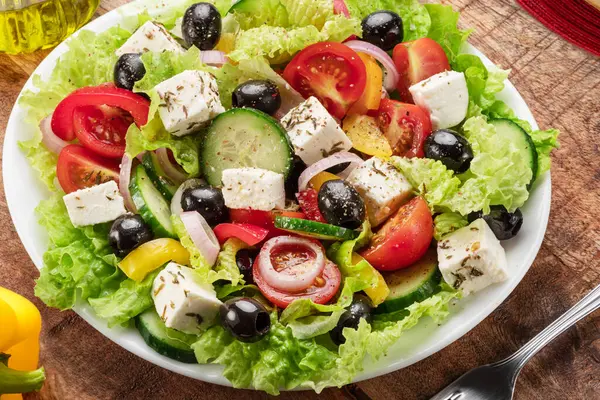 Griechischer Salat Auf Holztisch Serviert Und Fertig Zum Essen lizenzfreie Stockfotos