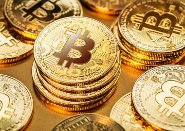 Gold bitcoin coins on a gold background. Symbol of electronic currency and blockchain technology. clipart