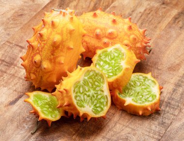 Ahşap zemin üzerinde kiwano dilimleri olan Kiwano meyvesi. 