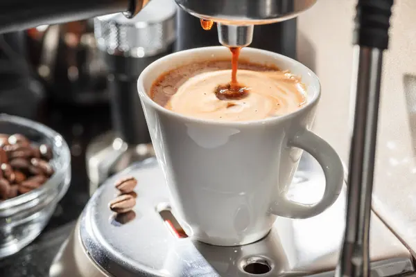 自动咖啡机把咖啡倒入咖啡杯特写 图库图片