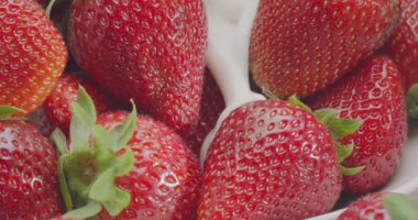 Yoğurt yavaşça çileklere dökülüyor. Yavaş çekim videosu.