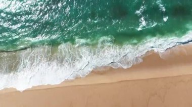 Bir yaz günü, Portekiz, Atlantik Okyanusu 'nda gün batımında kumlu okyanus sahilinin insansız hava aracı görüntüsü..