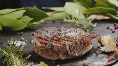 Gri servis taşında ızgara pirzola bifteği deniz tuzu ile tuzlanır..
