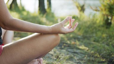 Kadın rahatlatıcı ve meditasyon yapan bir yoga pozisyonunda ya da Asana 'da oturuyor..